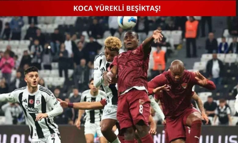 Beşiktaş ve Hatayspor futbolcuları, mücadele sırasında kafa topu mücadelesinde; üst kısımda "Koca Yürekli Beşiktaş!" yazısı yer alıyor.