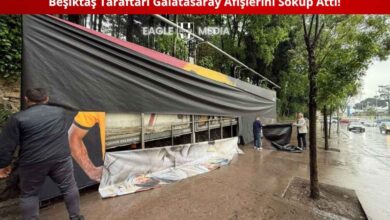 Beşiktaş taraftarları Tüpraş Stadyumu çevresindeki Galatasaray afişlerini sökerken çekilmiş bir görüntü, siyah-beyaz formalı gençler ellerinde afiş parçalarıyla birlikte görülüyor.