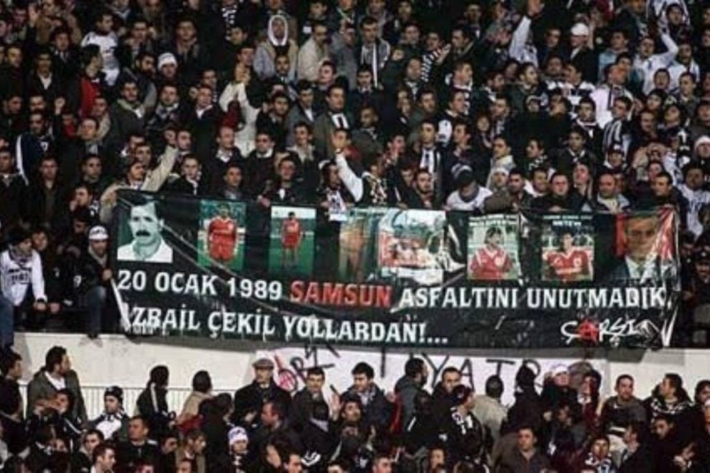 Yüksel Yıldırım Haddini Bil Tarihi Öğren 2 Son dönemde Samsunspor Başkanı Yüksel Yıldırım’ın Beşiktaş camiasına yönelik hadsiz ve provokatif açıklamaları, spor ve Beşiktaş kamuoyunda büyük tepki çekmektedir. Bu söylemler, sadece iki kulüp arasında gereksiz gerilimler yaratmakla kalmayıp, aynı zamanda sporda fair-play ruhuna da ağır bir darbe vurmuştur. Böyle bir tutum, kulüpler arası saygı ve dostluğun önemini unutan, geçmişteki ağır tecrübelerden ders almamış bir zihniyetin yansımasıdır. Pankart